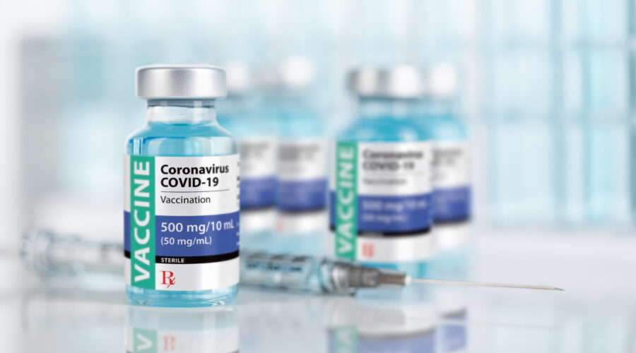 Coronavirus,Covid-19,Vaccine,Vials,And,Syringe,On,Reflective,Surface.