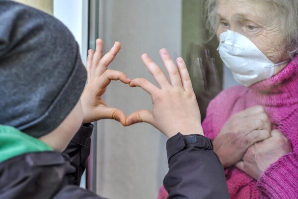 Grandmother,Mature,Woman,In,A,Respiratory,Mask,Communicates,With,Her
